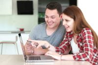 Smiling family standing in front of new home, illustrating co-borrower credit score eligibility change by Fannie Mae