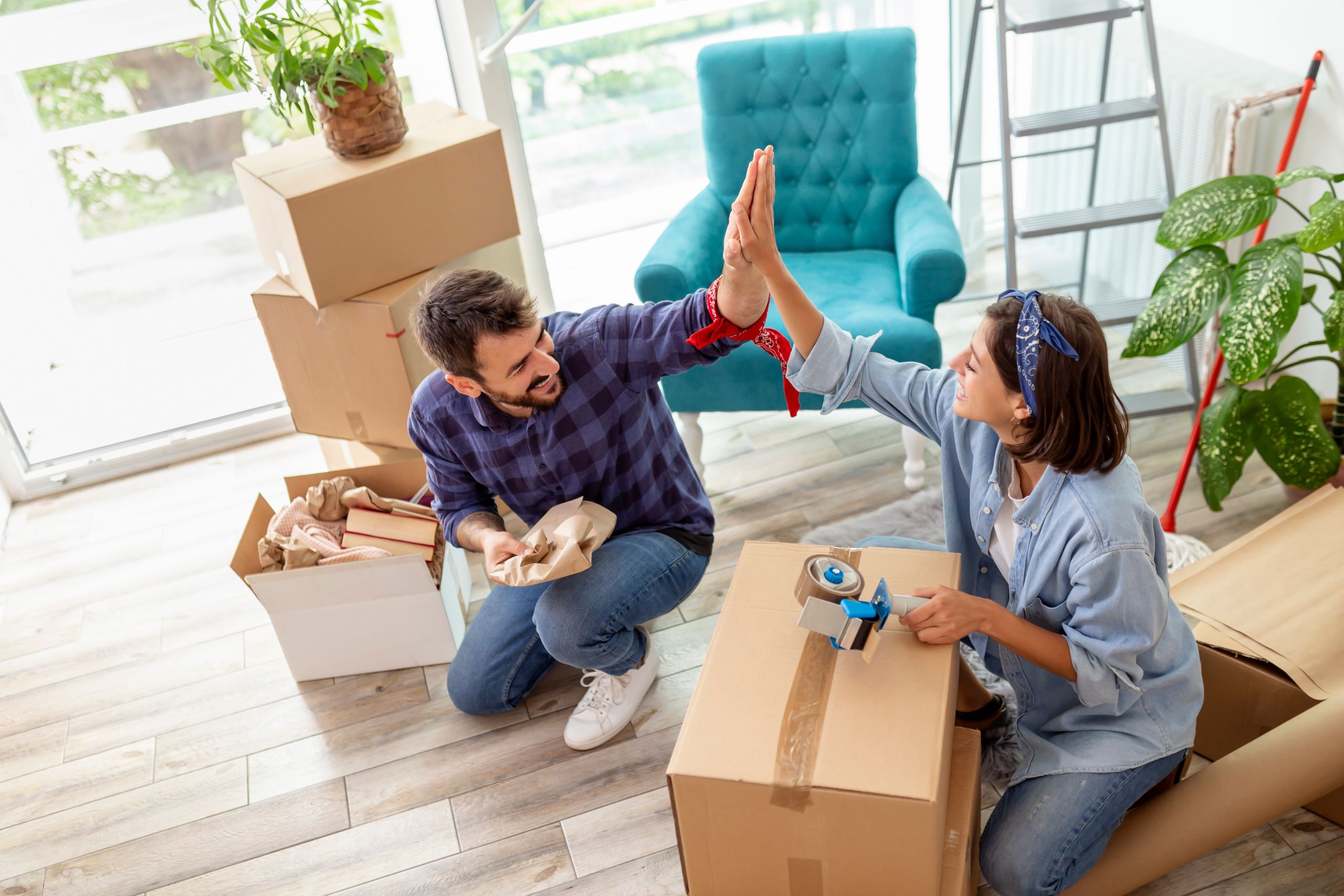 couple touching hands while packing boxes